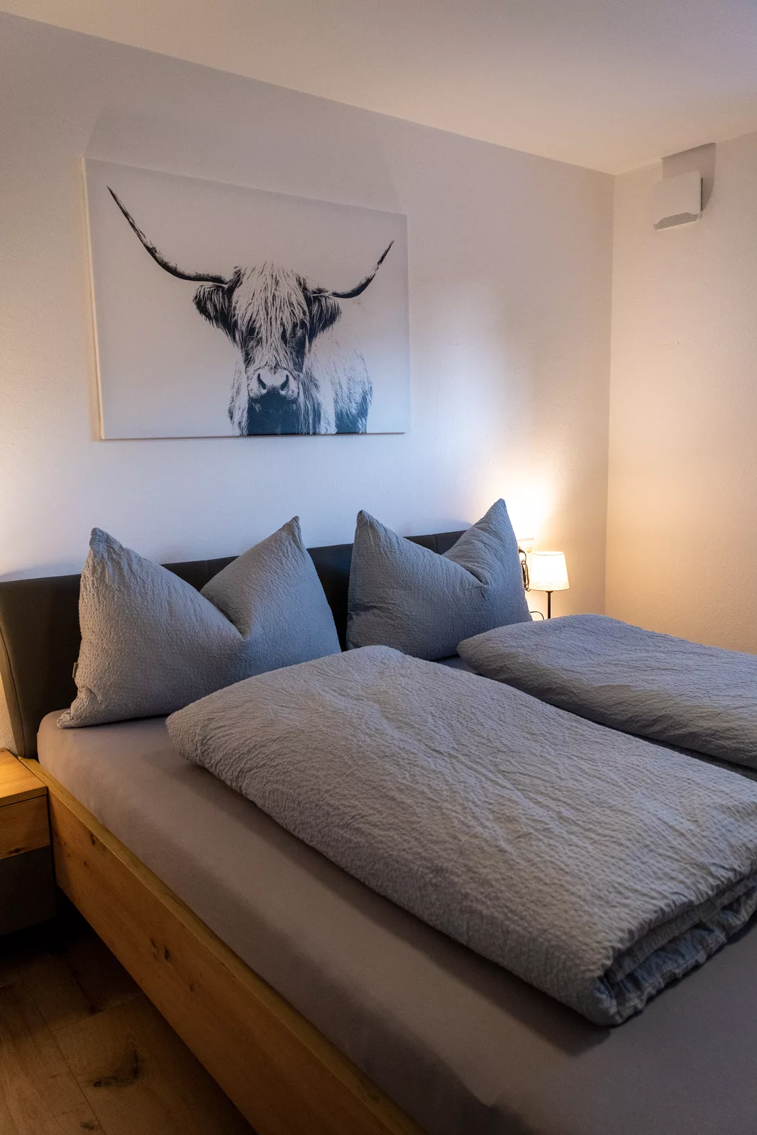 Gemütliches Schlafzimmer im Appartement Ausblick mit Holzbett und stimmungsvoller Beleuchtung