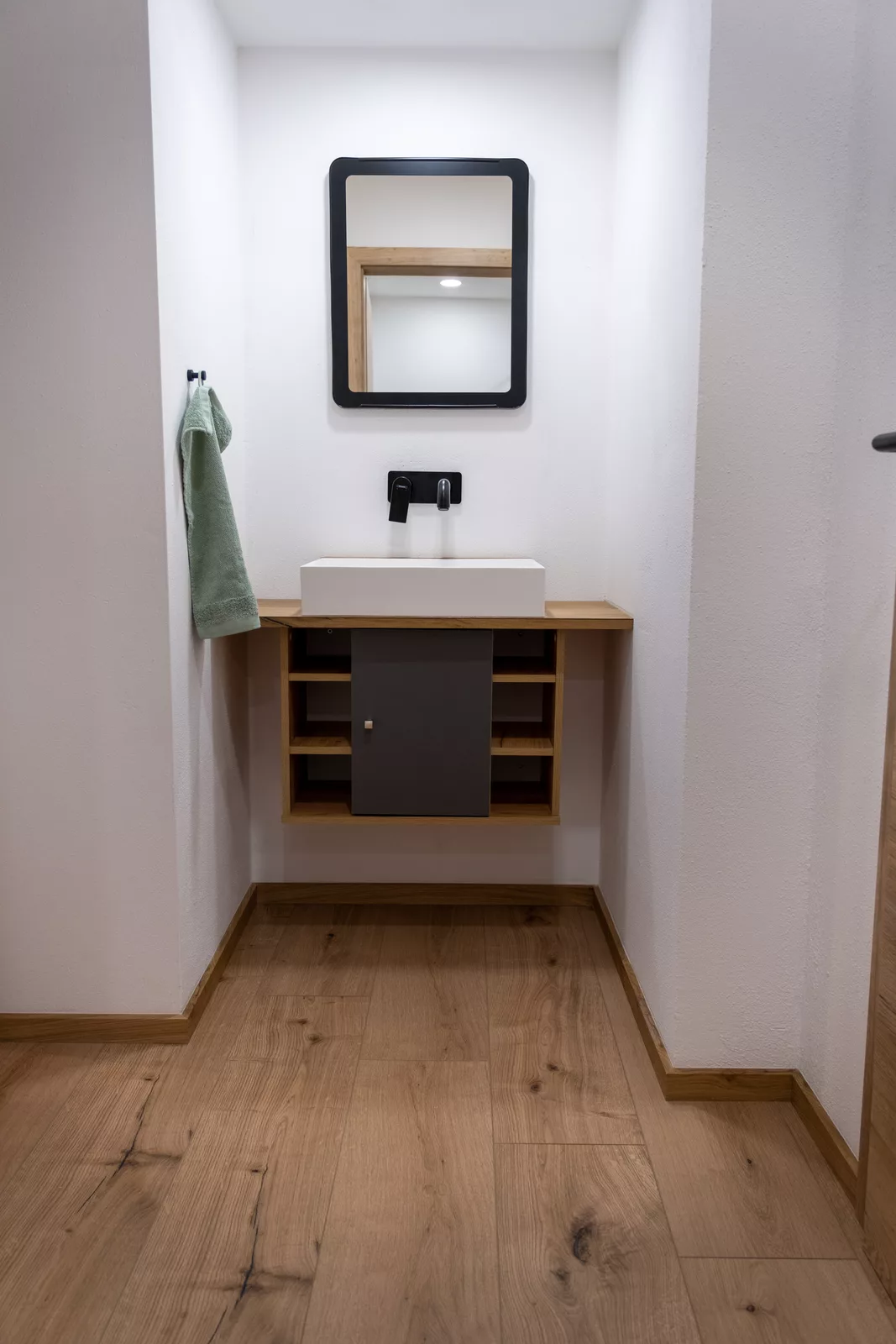 Modernes Badezimmer mit Holzboden und elegantem Waschtisch